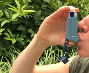 Photo of an adult using an inhaler