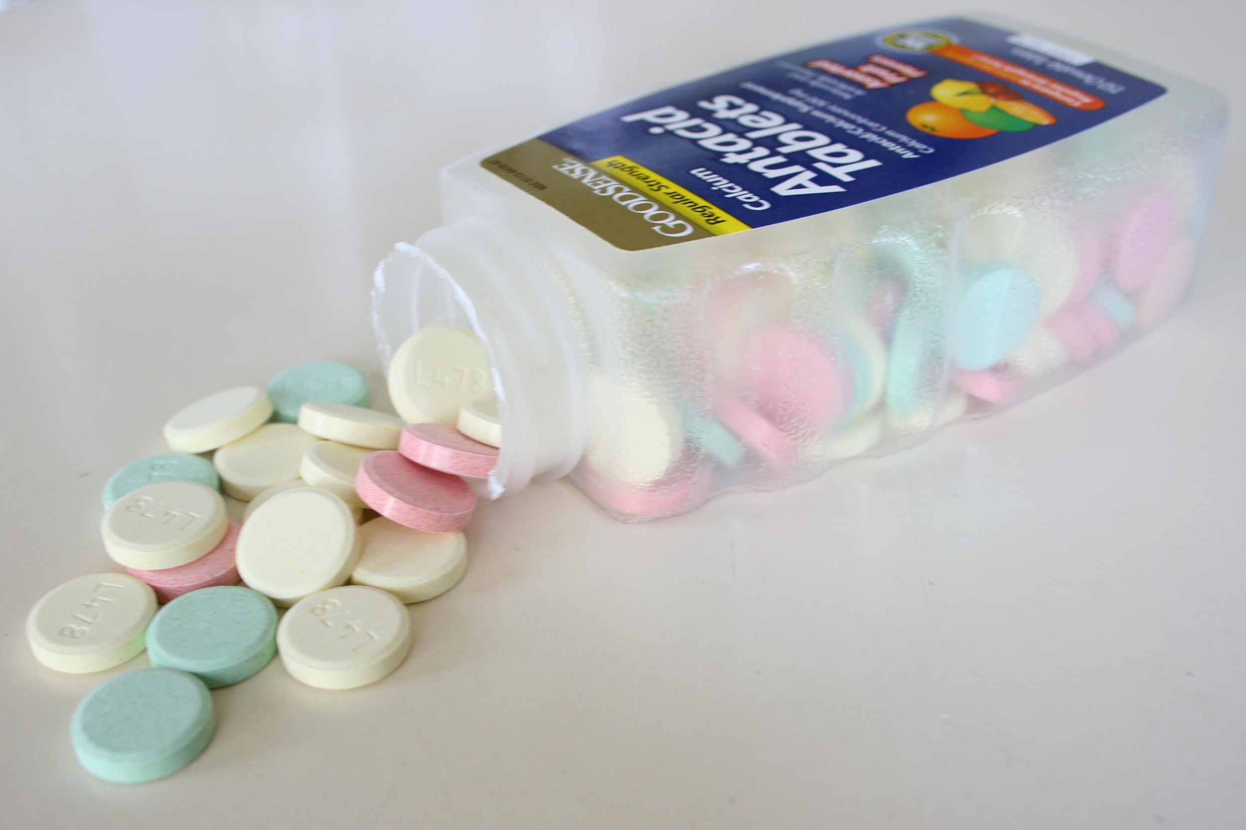 Photo of Antacid tablets bottle resting on side, with contents spilled out.