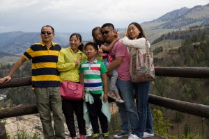 An Asian American family posing by a cliff on a vacation