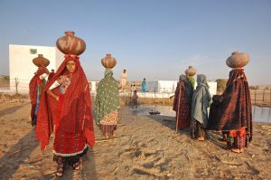 Women with bowls on their heads to carry water gather at the Somo Samo village well