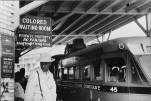 A sign illustrating segregation that reads "Colored Waiting Room: