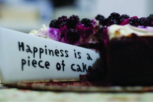 This image shows a knife cutting into a piece of cake. The knife says happiness is a piece of cake.