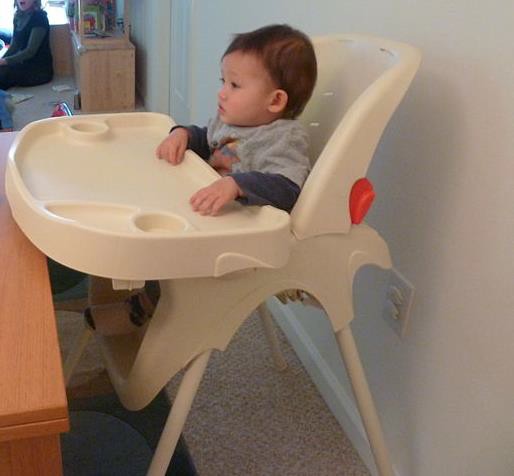 An infant sitting in a highchair