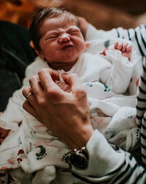 An infant making an angry facial expression.