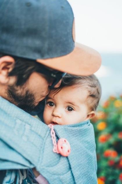 This baby-wearing father is creating trust with his infant child.