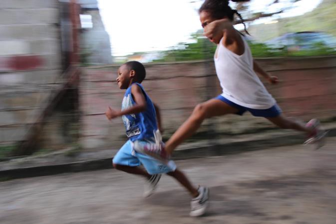 Two children running down the street in Carenage, Trinidad and Tobago