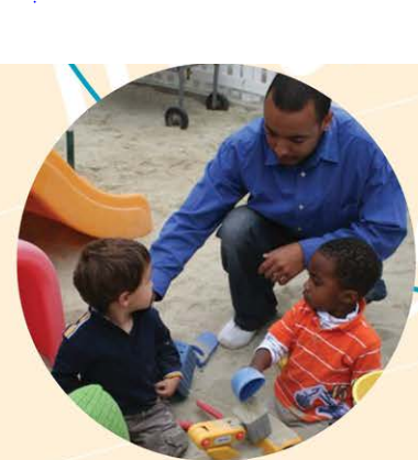 A black adult is on a playground with two young children who are black and white.