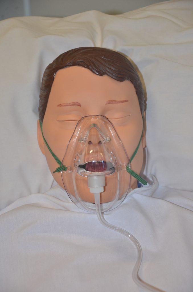 Photo showing simulated patient wearing a oxygen face mask
