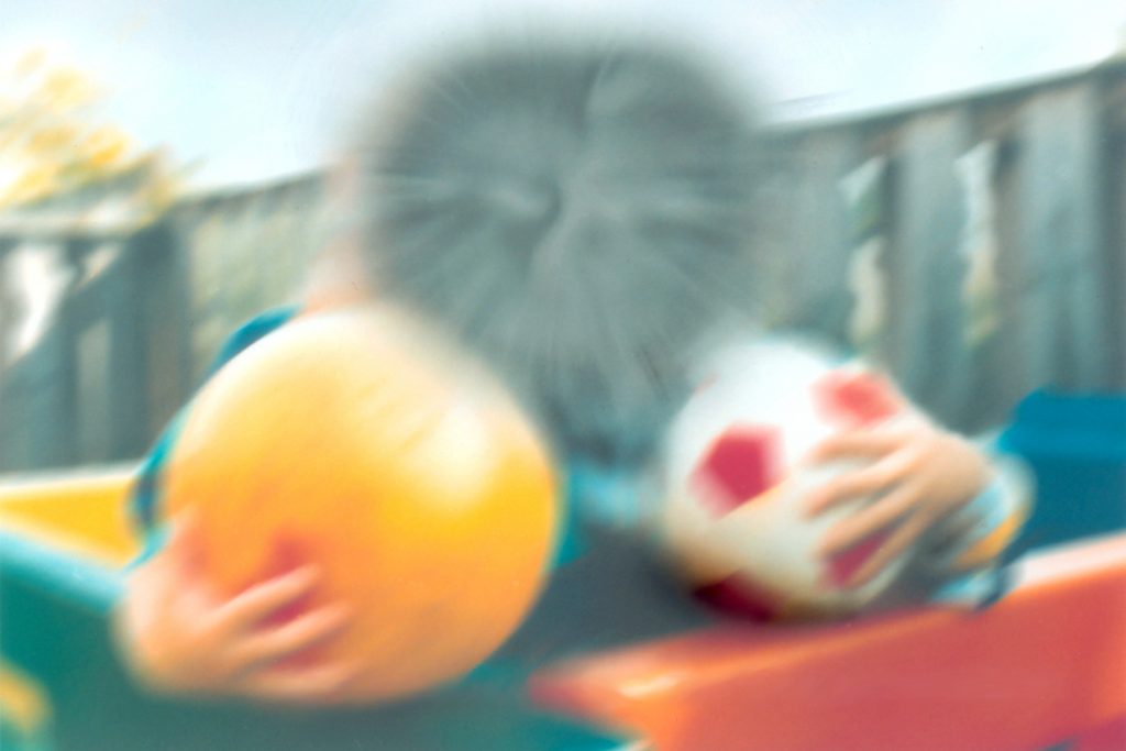 Photo of children, holding balls, adjusted to simulated macular degeneration