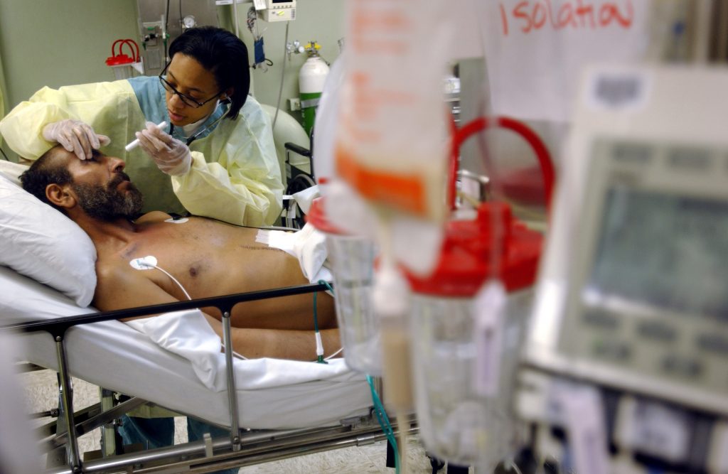 Photo of nurse assessing patient in an intensive care unit