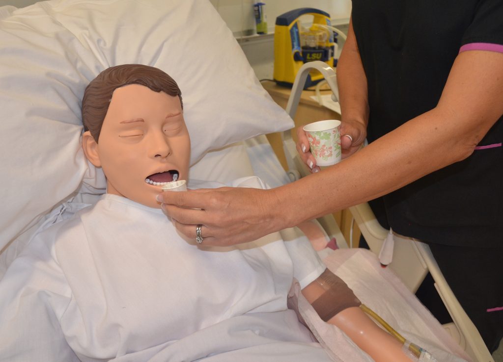 Photo showing a simulated patient positioned upright for medication administration