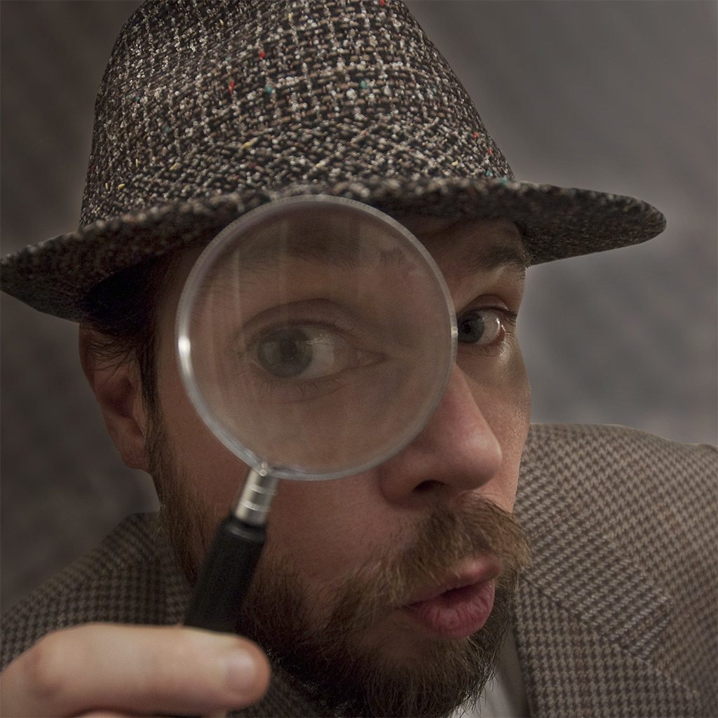 Photo showing person looking at camera through a magnifying glass