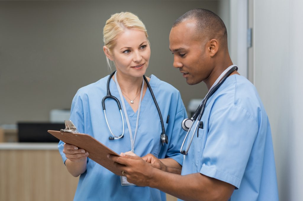 Image showing two nurses discussing a chart both are holding