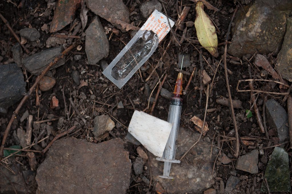 Photo showing a closeup of a used syringe and packaging litter