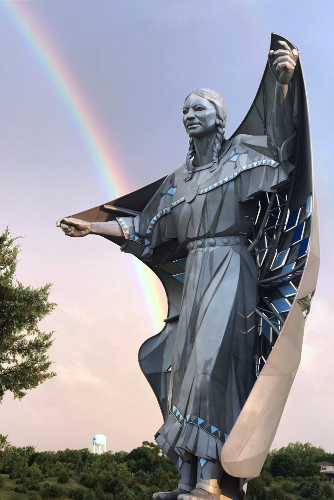 Image showing statue of native american woman with rainbow in the sky beyond it