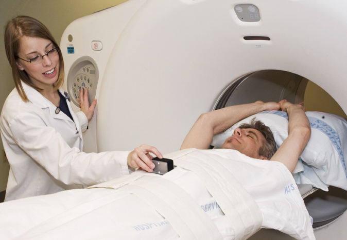 Image showing technologist assisting simulated patient during CT scan