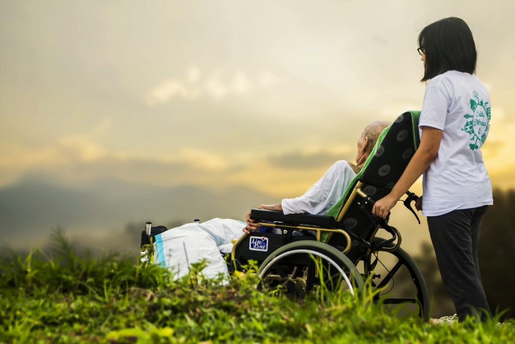 Image showing a caretaker assisting a hospice patient reclining in a wheelchair