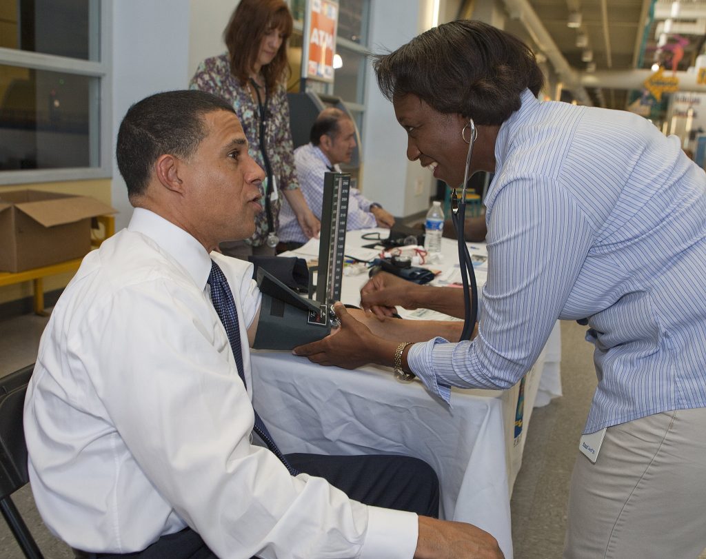 Photo showing medical personnel checking a person's blood pressure