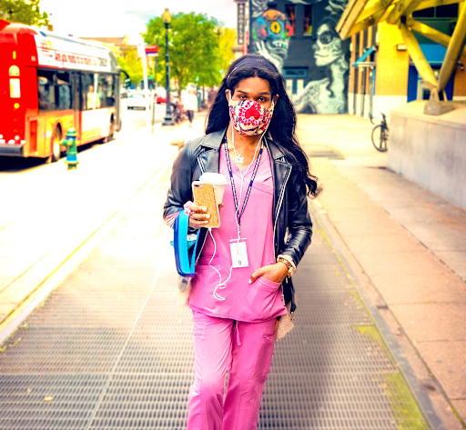 Photo showing a masked nurse walking down a city sidewalk