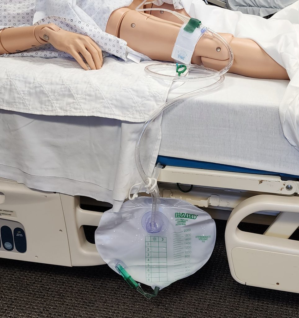 Illustration showing a simulated patient with urinary catheter with a collection bag in place