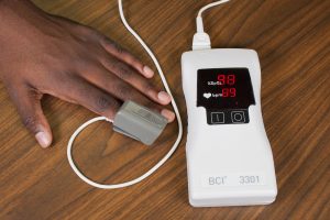 Photo showing a Pulse Oximeter in use on a patient's hand