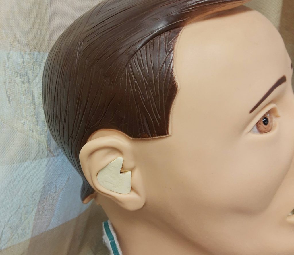 Photo showing Simulated Hearing Aid Placed Inside a Mannequin Ear