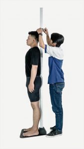 Photo of two people Measuring Height With a Stadiometer