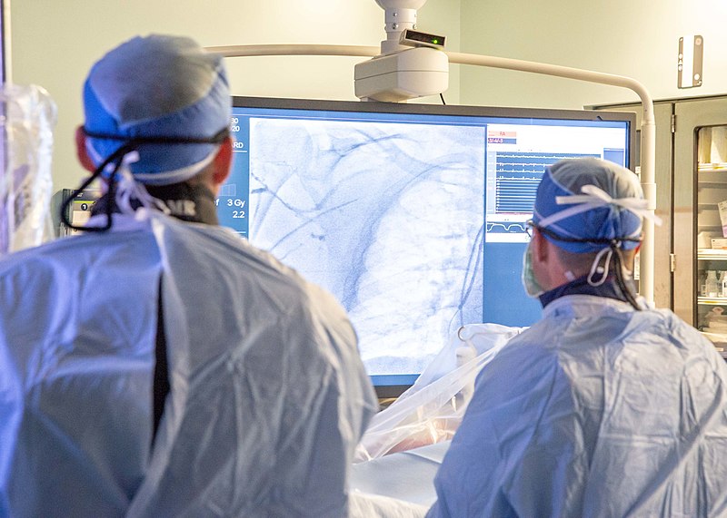 Photo showing medical staff looking at a video screen during an Angiogram and Cardiac Catheterization procedure