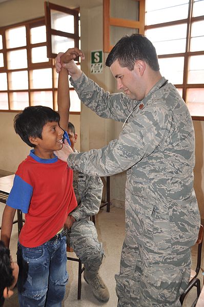Image showing Range-of-Motion Testing of the Shoulder of a child, by a military member