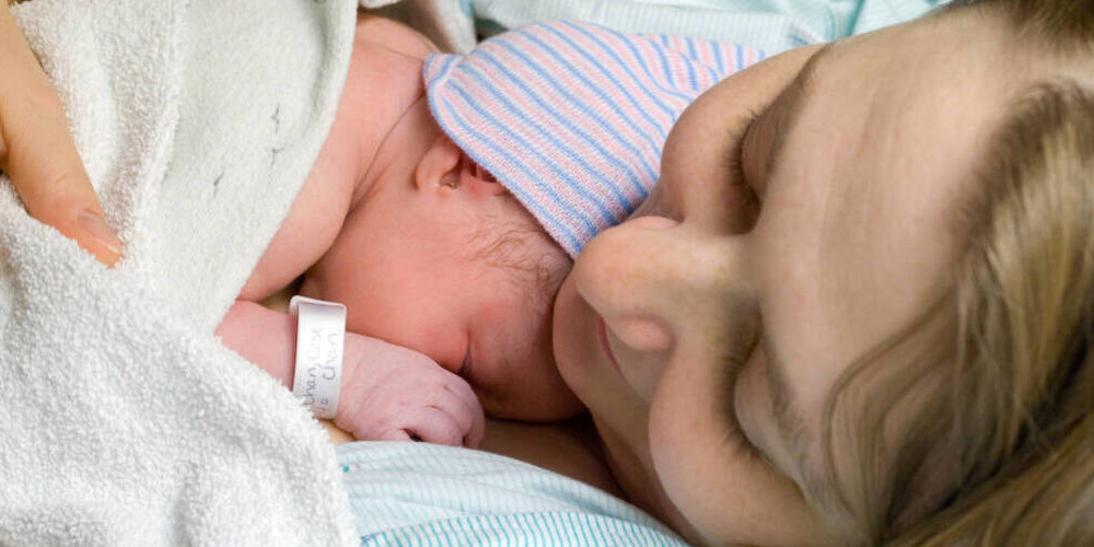 Photo showing a closeup of a mother holding her newborn