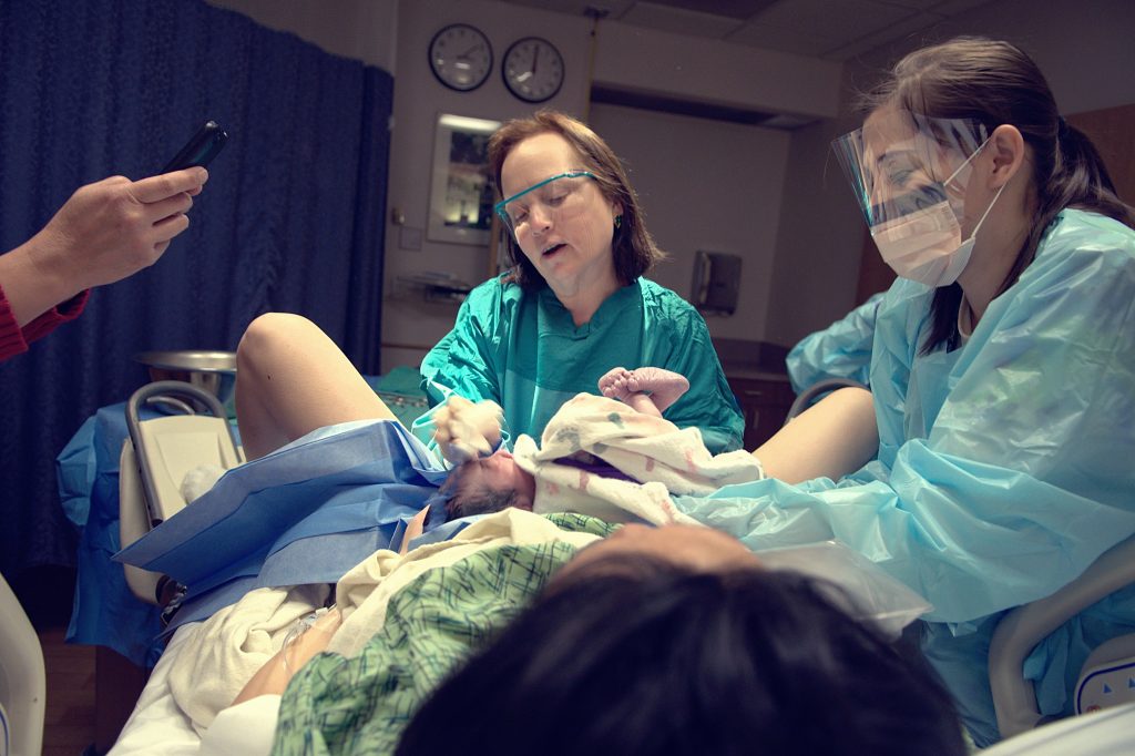 Photo showing nurses providing care to a newborn