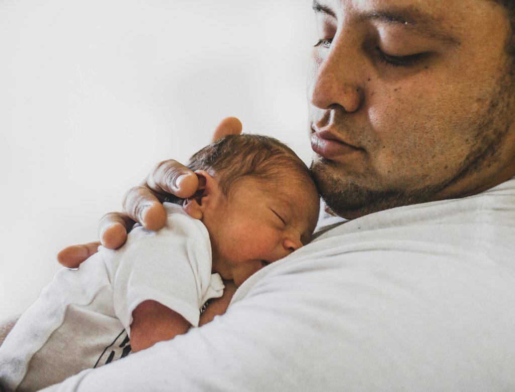 Photo showing a father holding his newborn