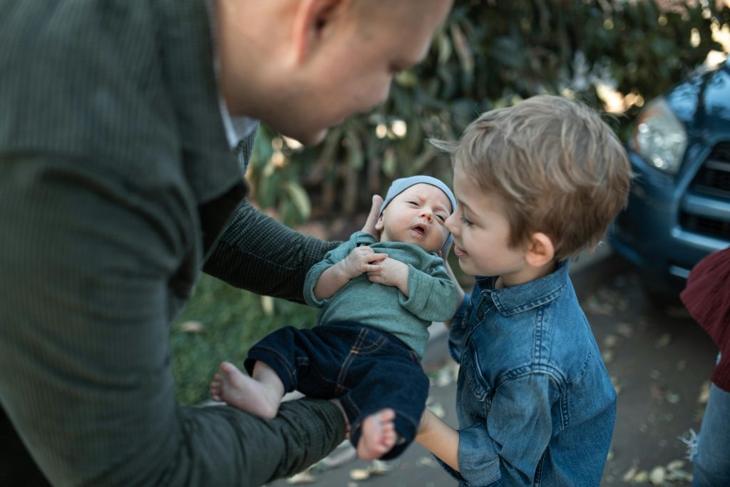 Photo showing a parent introducing a newborn child to an older sibling