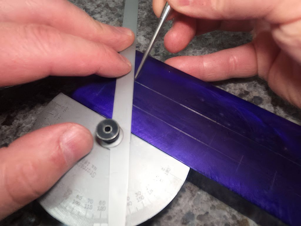 Fingers are holding A protractor to scribe an angular line on a part