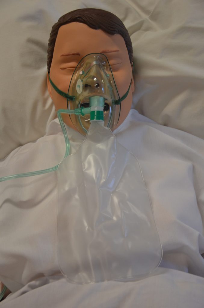 A simulated patient is wearing a Non re-breather mask